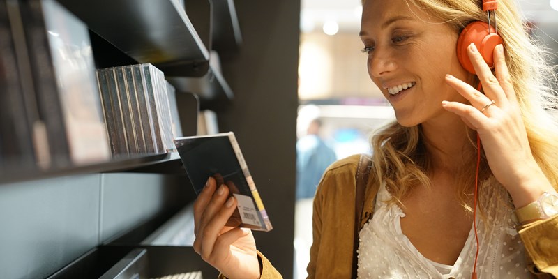 Woman in multimedia store testing new music discs